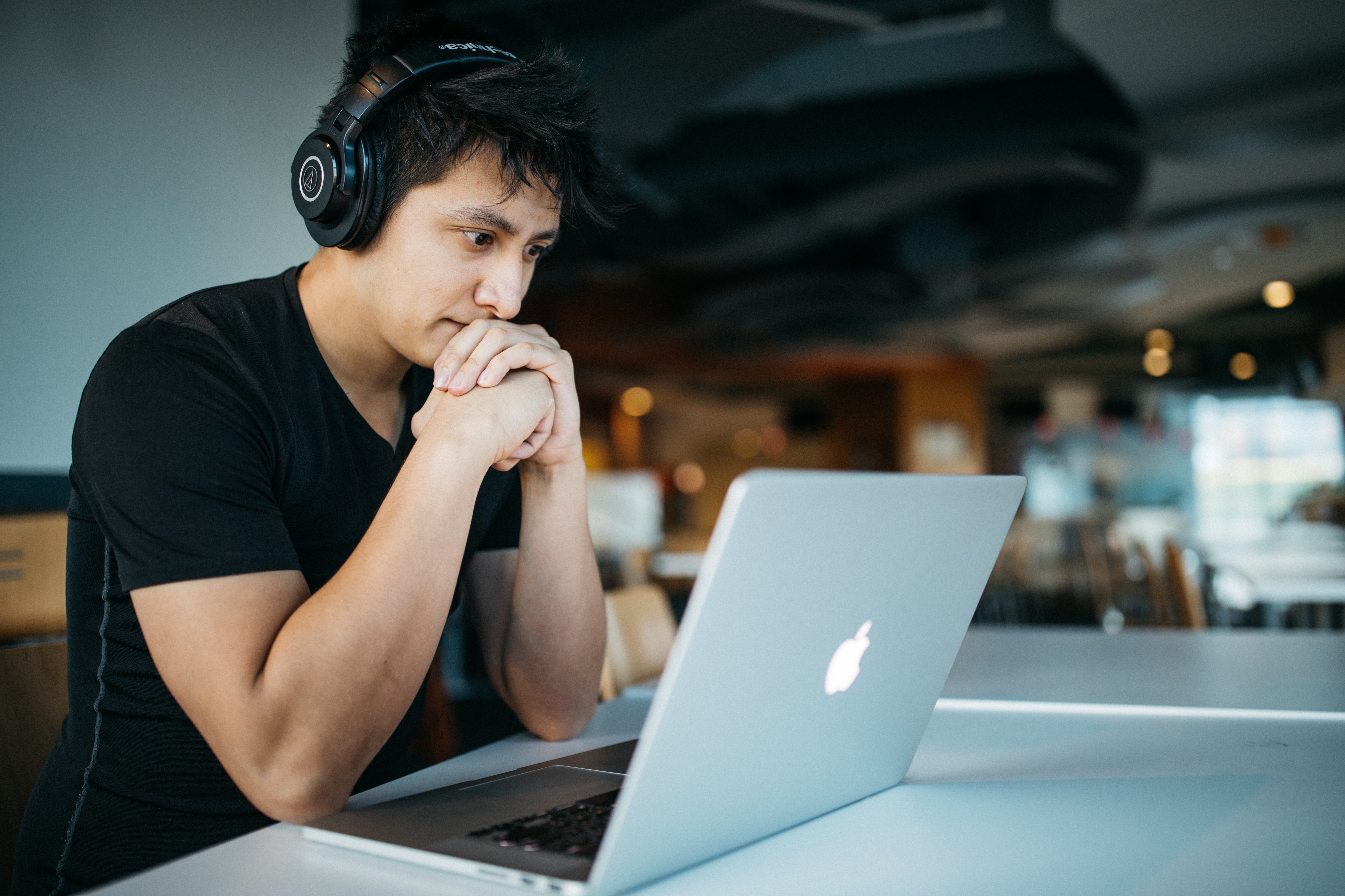 Man with headphones looking at a laptop