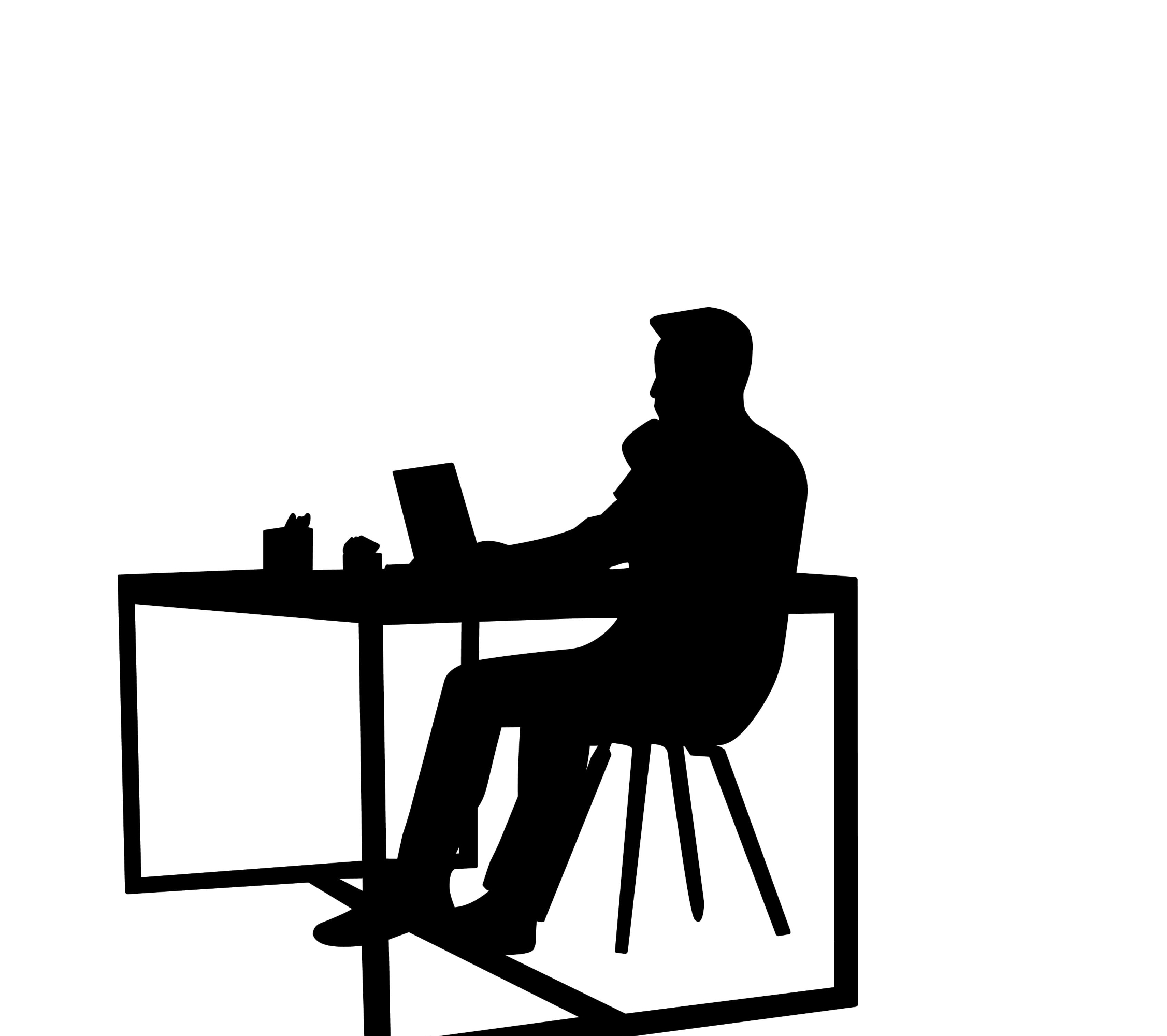 silhouette of person at desk on laptop