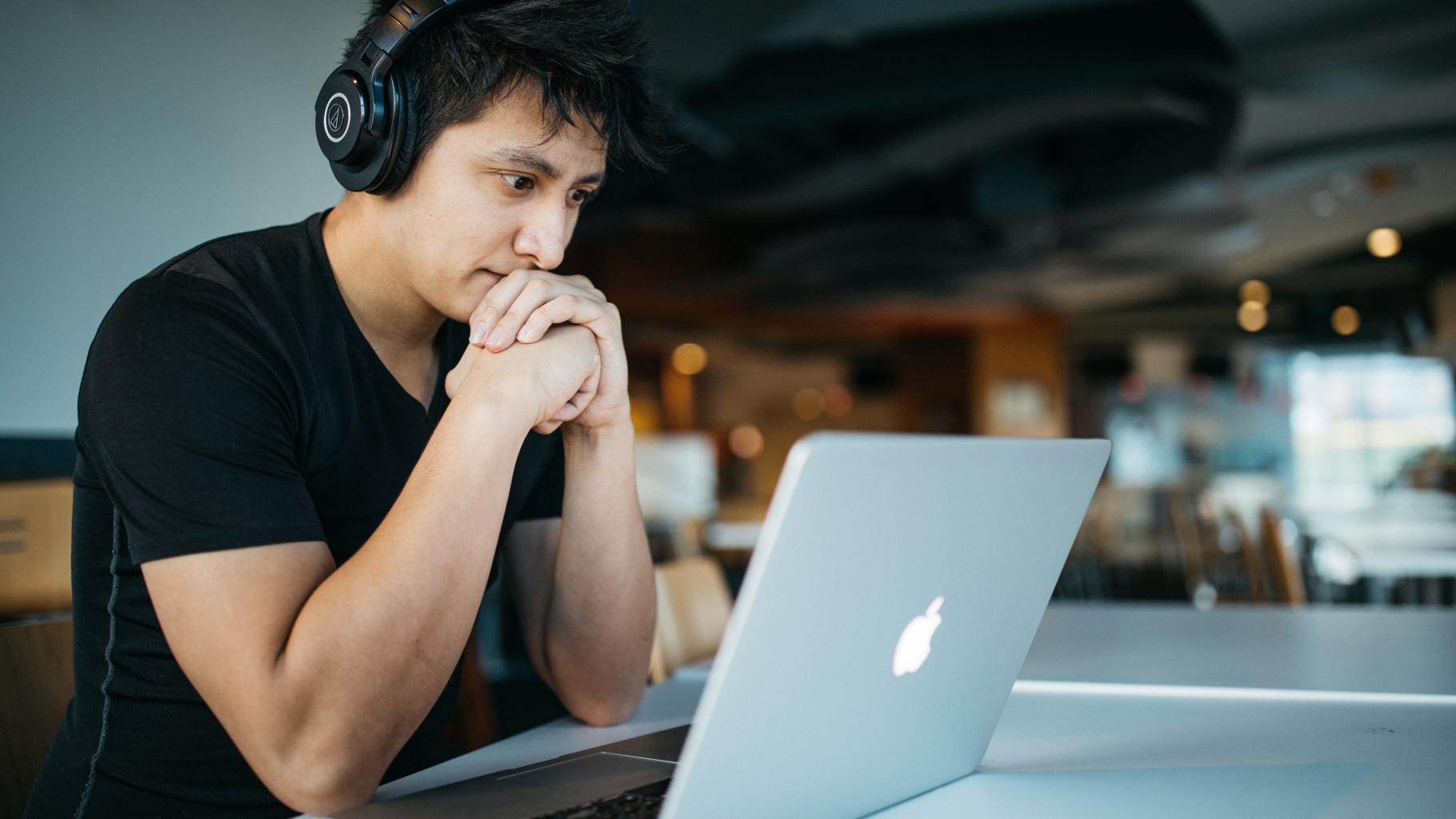 Man with headphones looking at a laptop